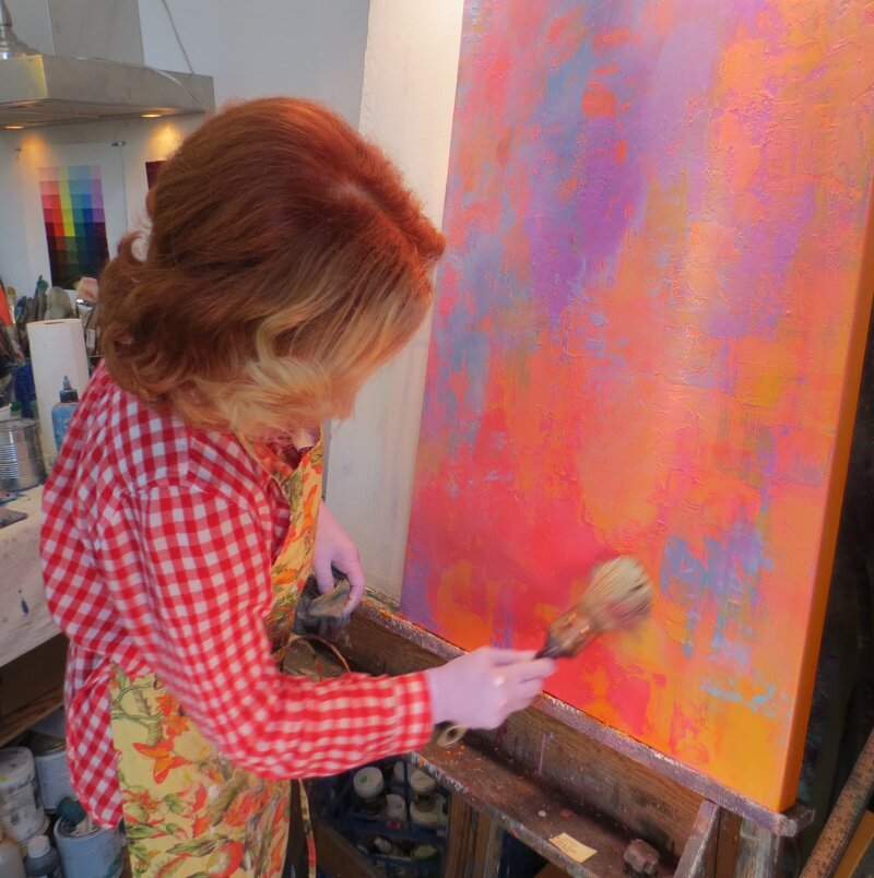 woman wearing a red checked shirt while painting