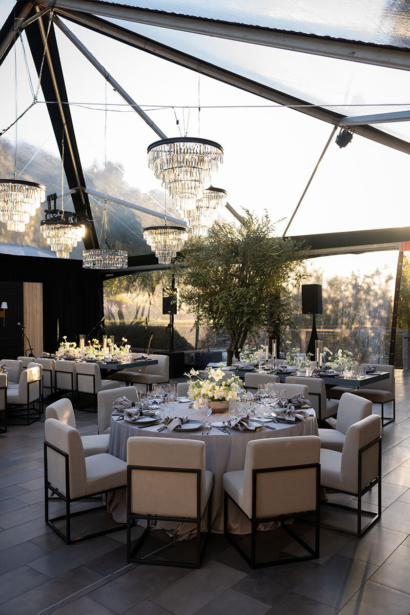 wedding guests in black tie gather for cocktail hour outside