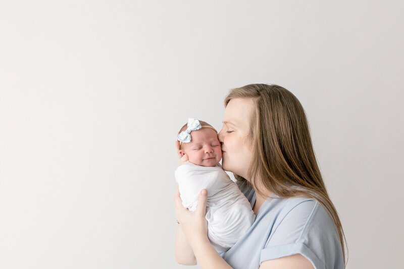 Mother holding newborn taken by savannah portrait photographer​ Tiffany Bradley