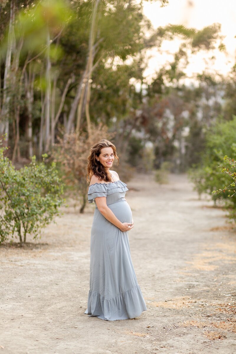 LA maternity photo at outdoor park with woman in long blue dress