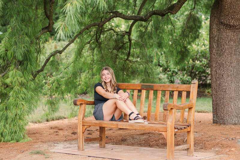 Senior girl sitting on a bench under a tree by Baltimore photographer