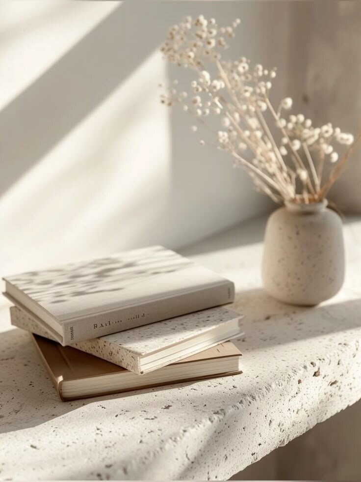 Neutral-toned bench with vase, flower, and design books – calming visual from Karla Jane Web Design.