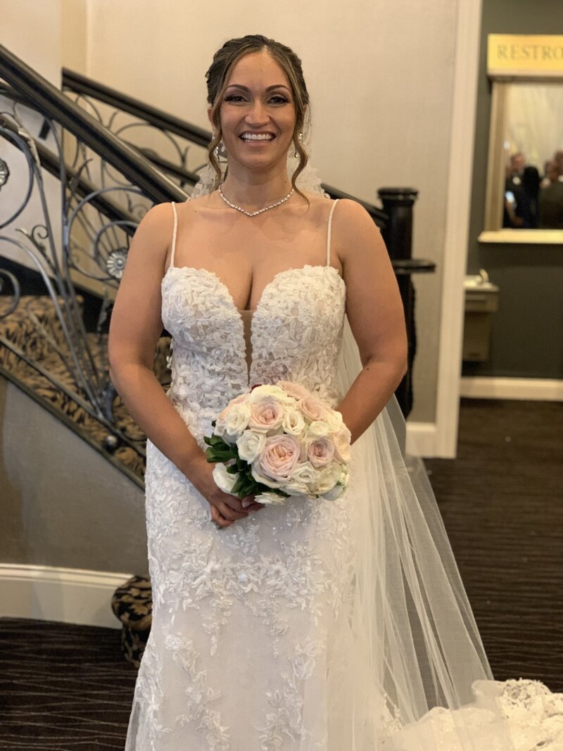 beautiful bride smiling with bouquet in hand
