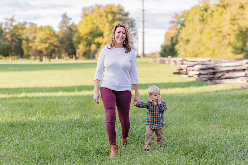 A mom walking through a field with her son at sunset in Chantilly, VA.