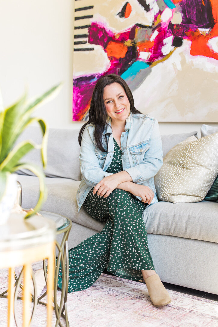 Lauren is sitting on a couch looking at the camera