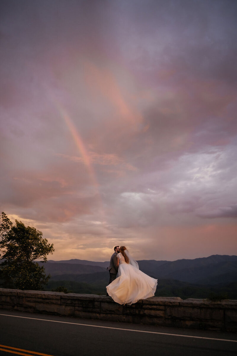 bride and groom elope to Gatlinburg in the foothills parkway with a rainbow overhead shining through the clouds