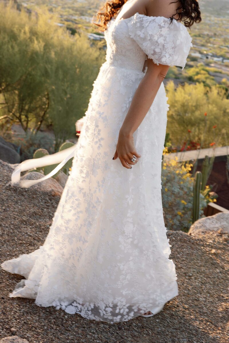 Bride walks through the Paradise Valley desert holding her bouquet.