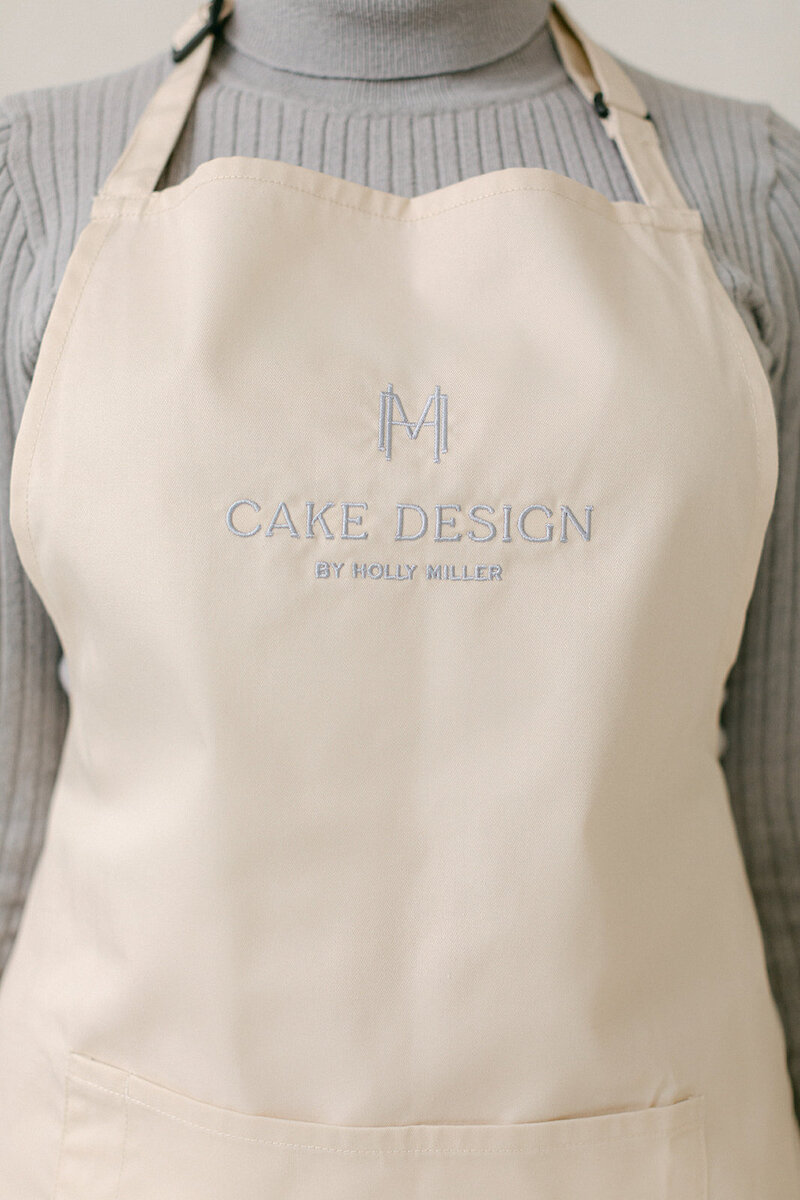 Close-up of Holly Miller’s branded apron featuring embroidered logo