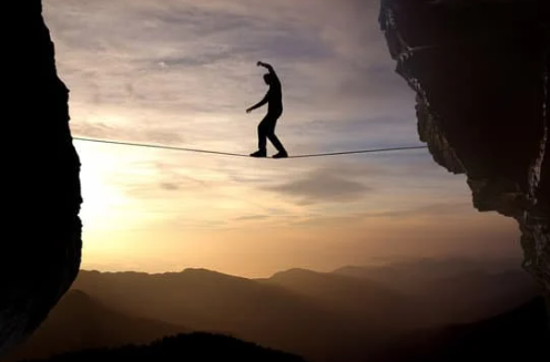 Silhouette of man on the rope concept  ofrisk taking and challenge; Getty Image