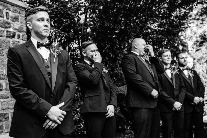 groom and groomsmen stand in awe of bride walking down aisle