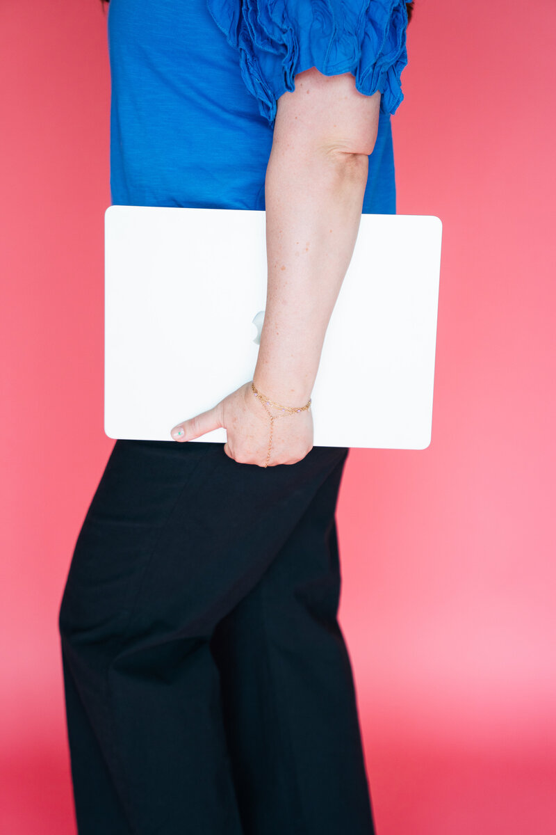 heather holding laptop at side