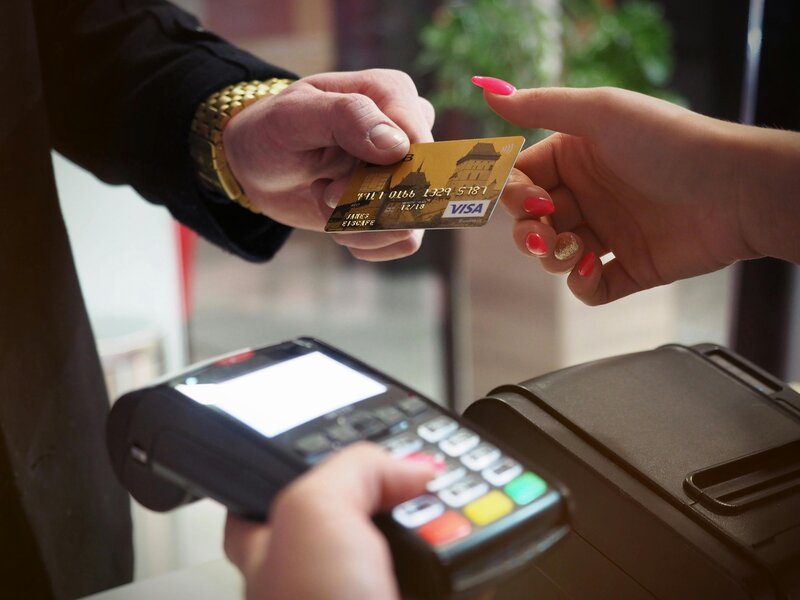 man handing over credit card to pay