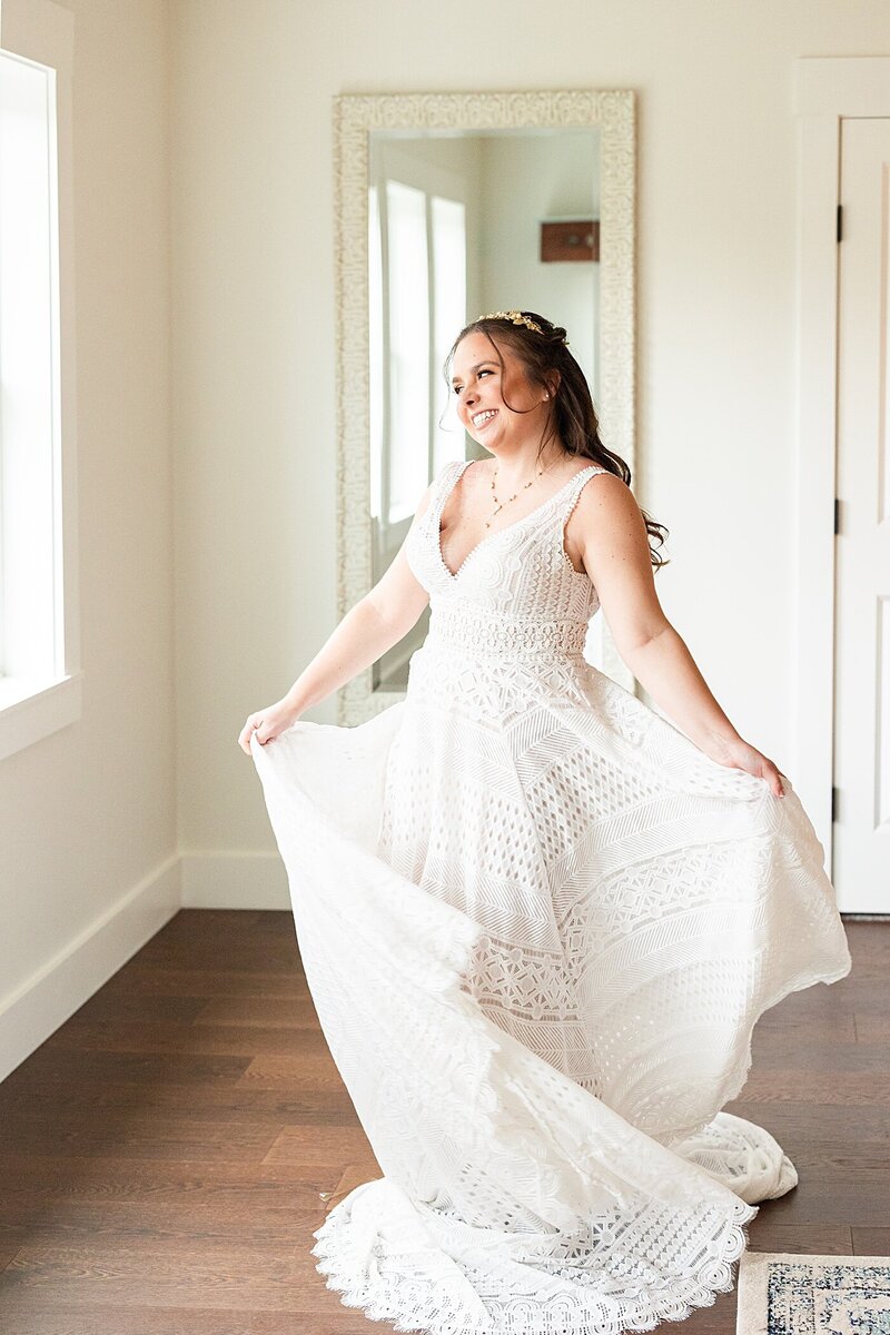 Bridal portrait of the bride twirling in her dress in the bridal suite at Avonlea Farms.