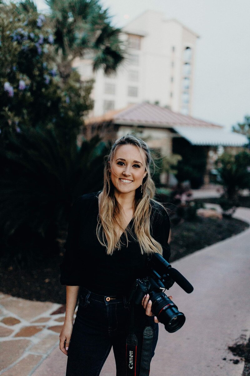 woman smiling holding camera