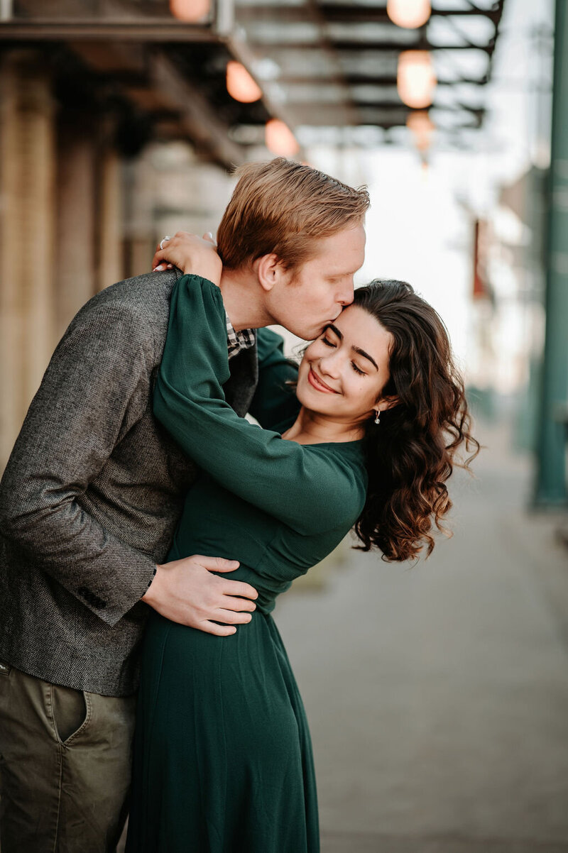 engagement session with man kissing womans forehead