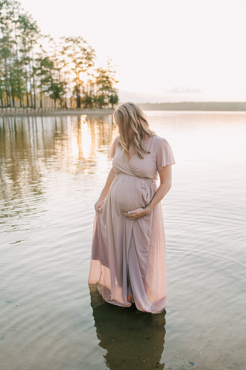 Expecting mom taking a moment to reflect on her last few weeks before her baby will be here. Mom is wearing a pink gown from my client closet. Session took place at dusk at Clarks Hill Lake