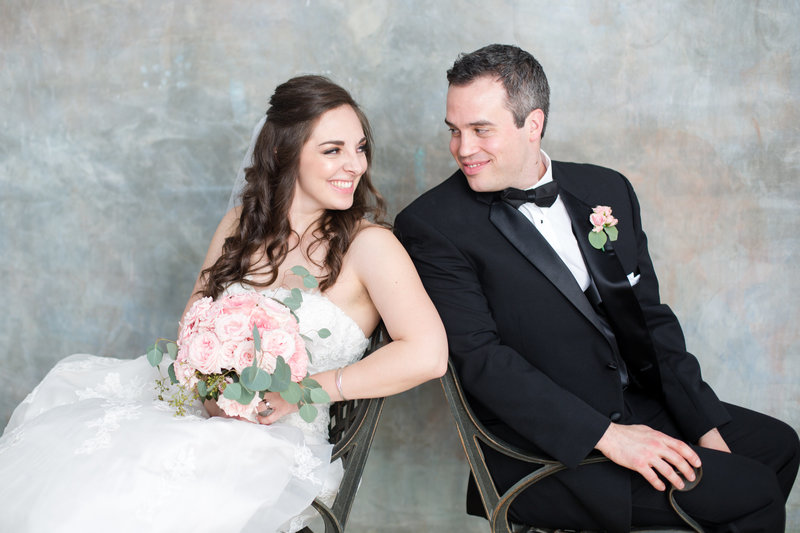 Roswell wedding couple lean back to back and smile at each other