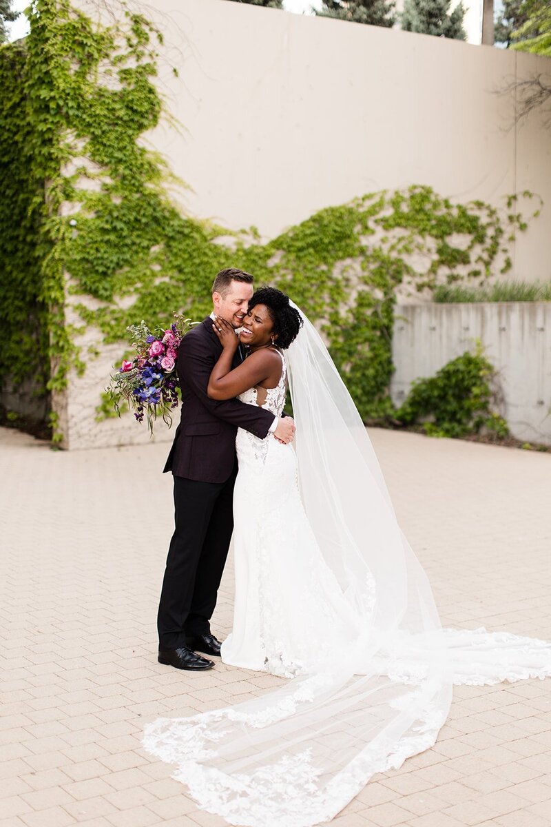 Bride and groom laughing outside of The Kauffman