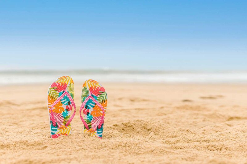 colorful sandals stuck in sand