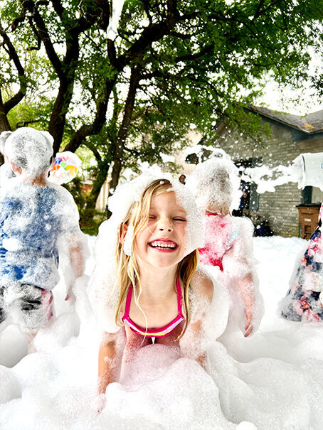 Smiling children playing in foam