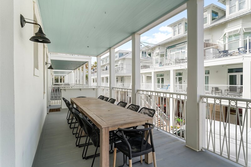 Expansive outdoor dining patio with seating for 14 at The Florida House, a vibrant vacation rental near Panama City Beach, 30A, and Carillon Beach attractions.