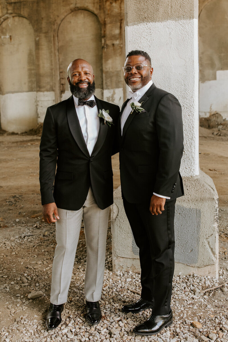 Two grooms in tixes with boutonnieres in Baltimore