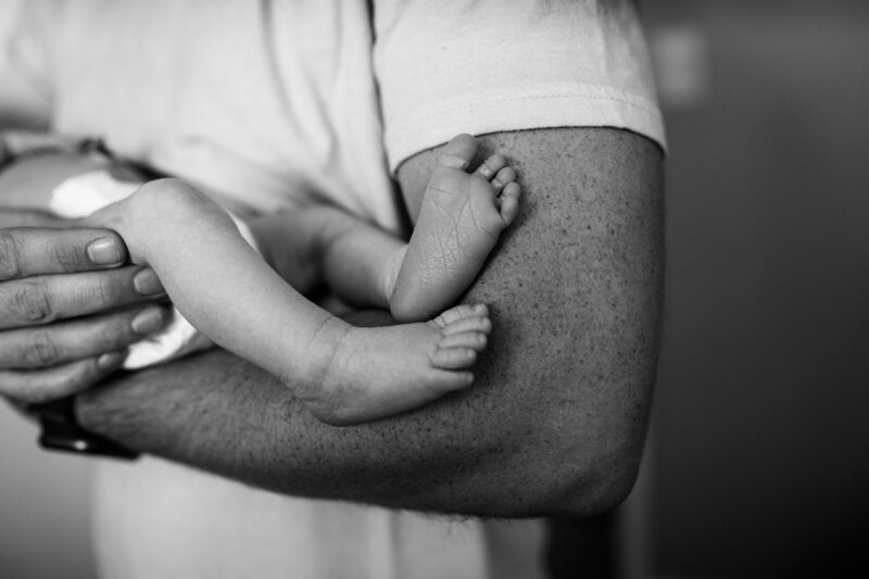 Black and white photo  of a man holding a baby