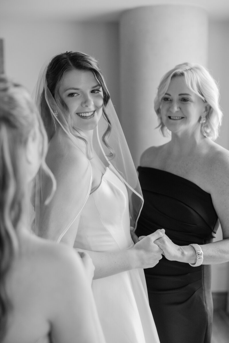 A portrait of a bride in black and white with her mom looking at her and her sister in the foreground at the Ben in West Palm Beach. 