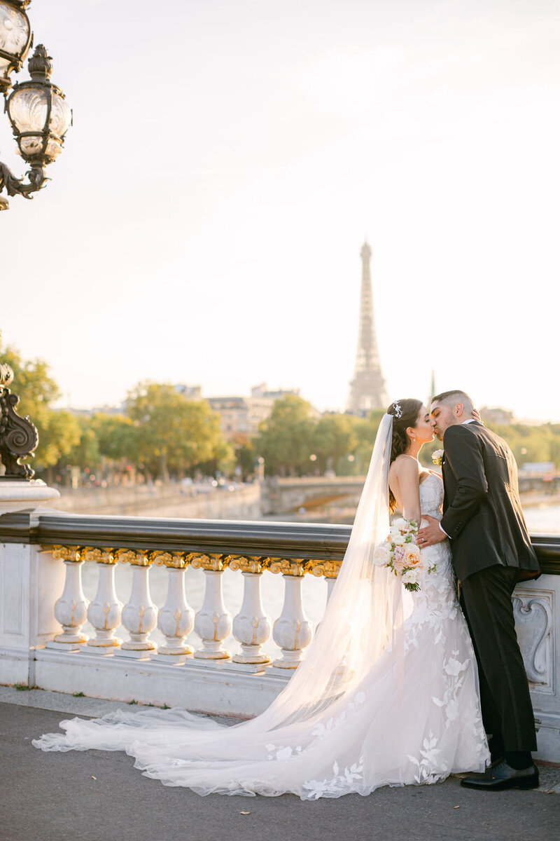 a couple kissing in front of the Eiffel Tower