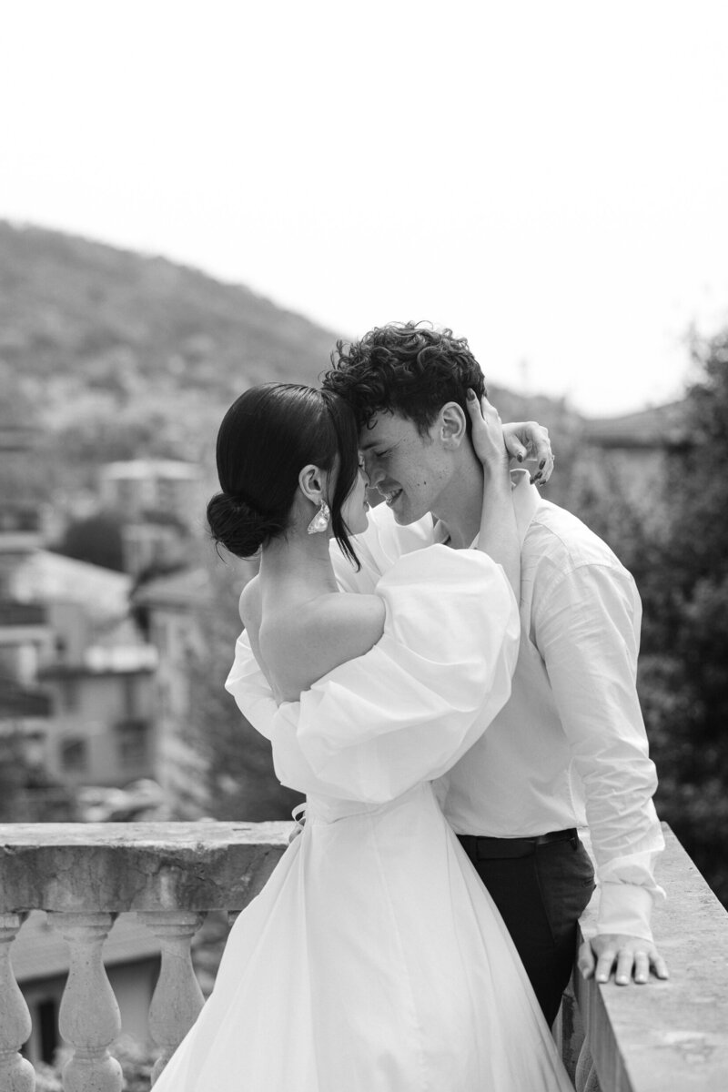 bride and groom embracing on a balcony in Italy