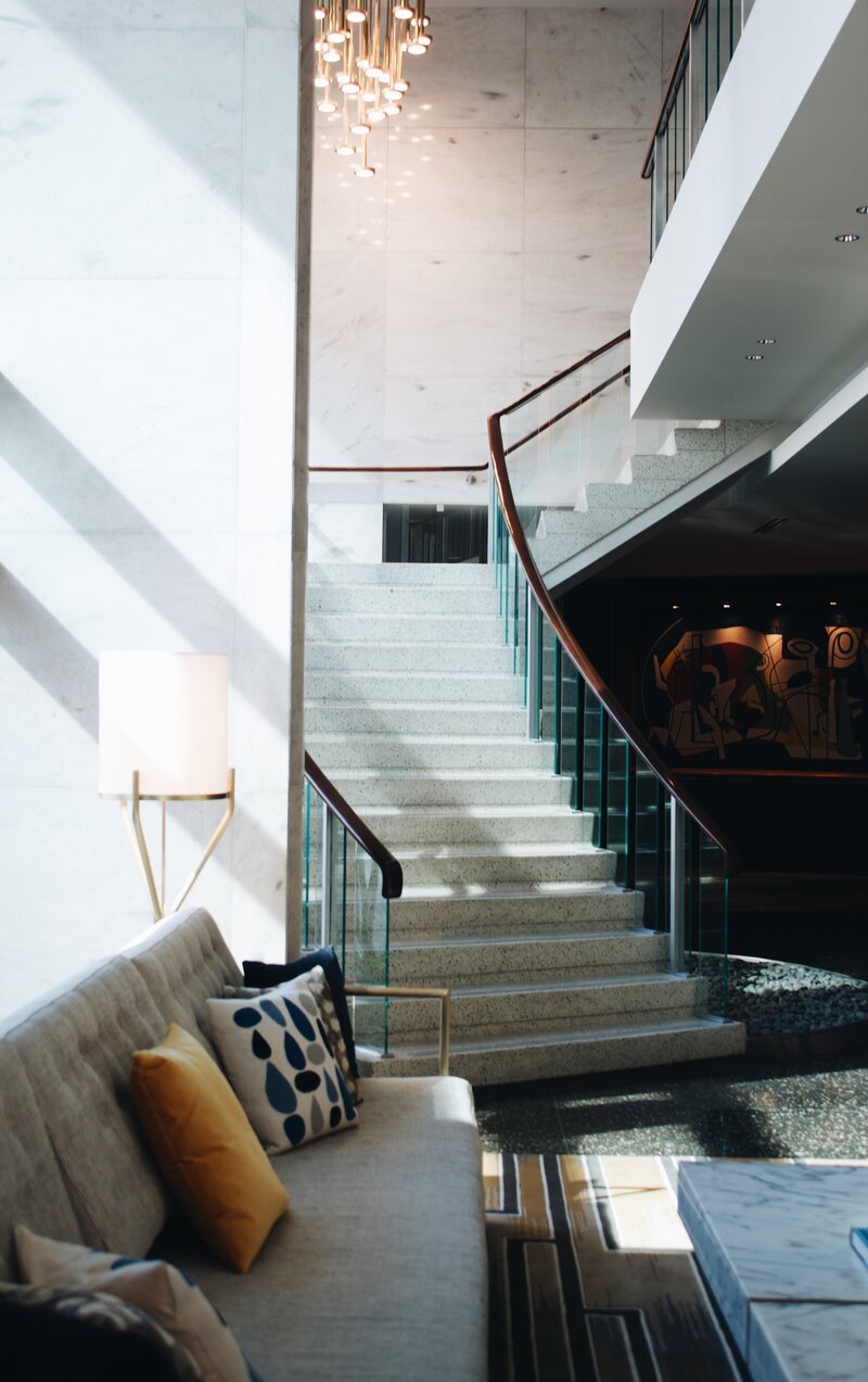 boutique hotel lobby with glass walled staircase