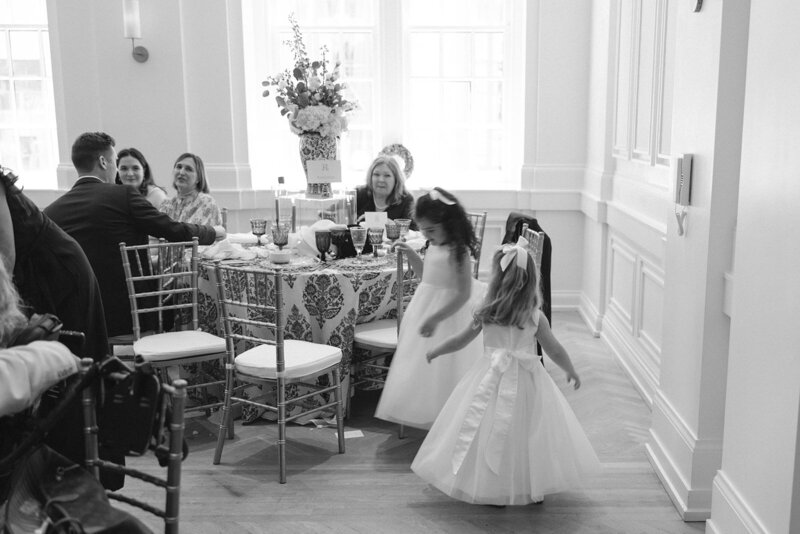 Black and white image of flower girls twirling at Nashville wedding
