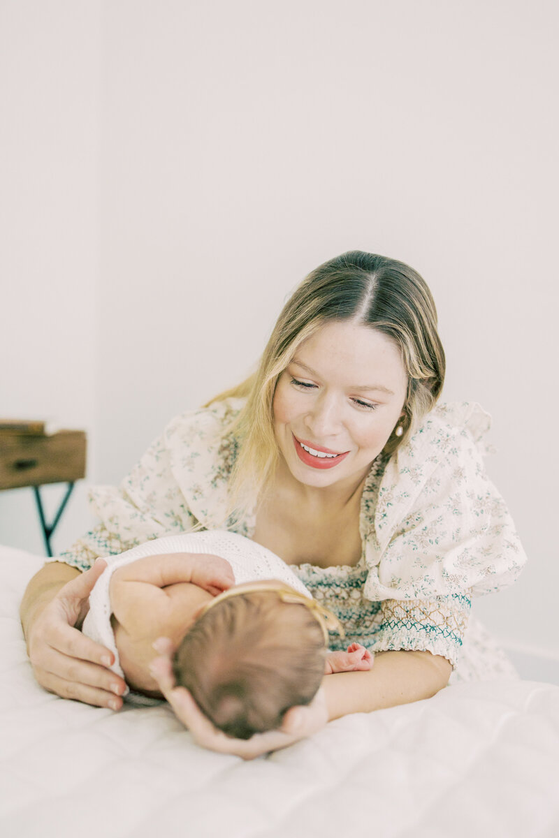 Austin mom smiles at her newborn baby.