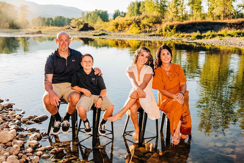 Missoula family sitting outside on stools in the Clark Fork River