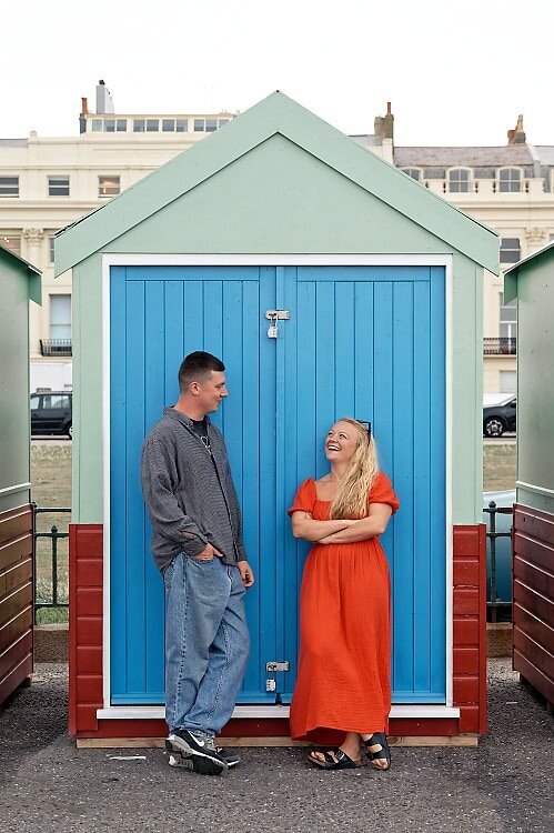 engaged couple with bride to be looking over her shoulder towards the camera