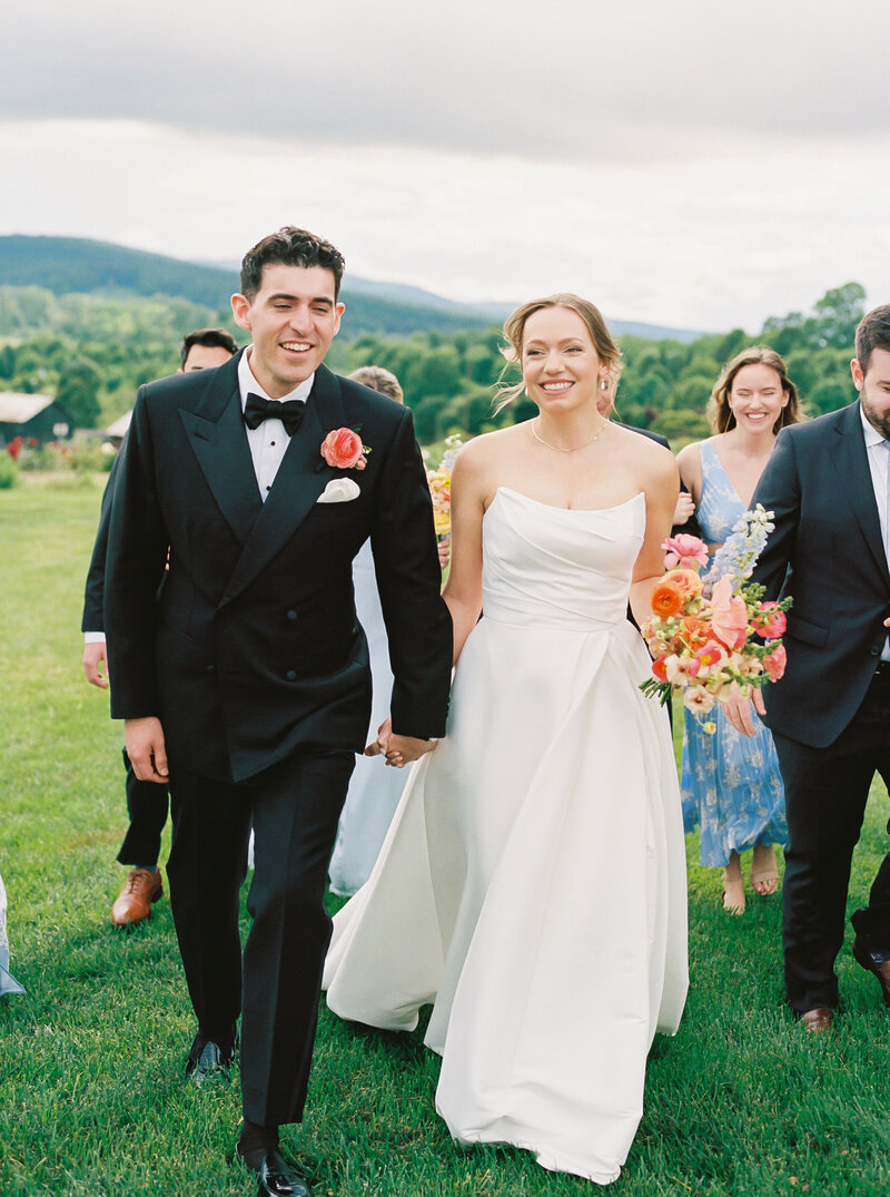 Bride and groom walk hand in hand in the Blue Ridge Mountains