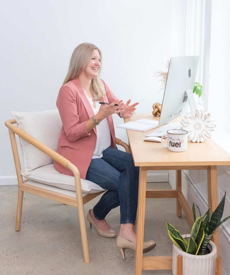 Maureen sitting at desk talking to custom web design client via Zoom call