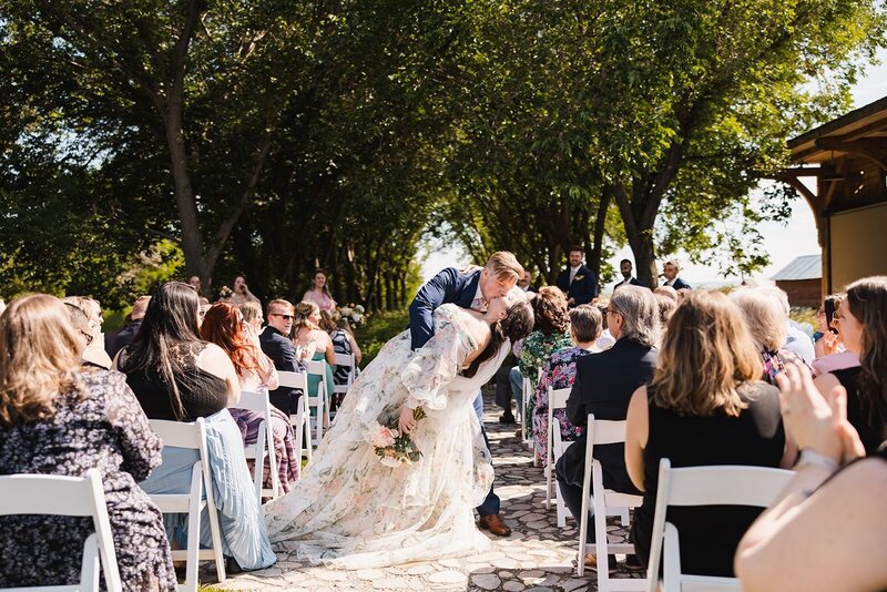 Couple kissing as they walk down the aisle after their ceremony