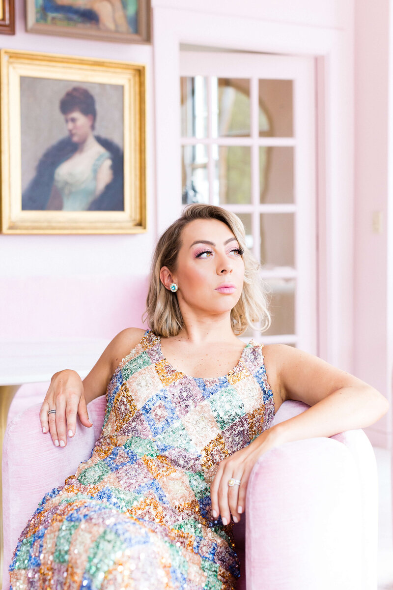 woman with blonde hair wearing big earrings and sparkly beaded dress posing for camera