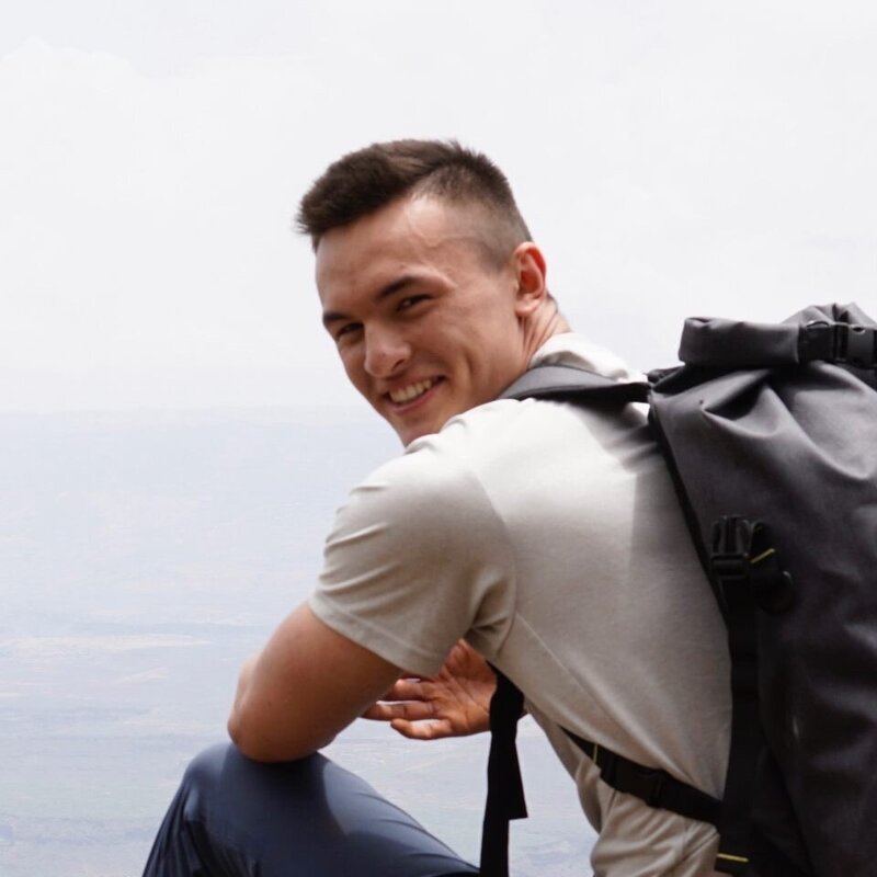 Picture of Head Product Designer Steven Bleau smiling and wearing a white shirt and backpack