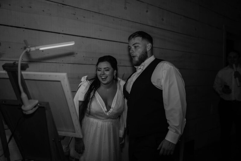 Bride and groom visibly thrilled with their custom wedding painting reveal