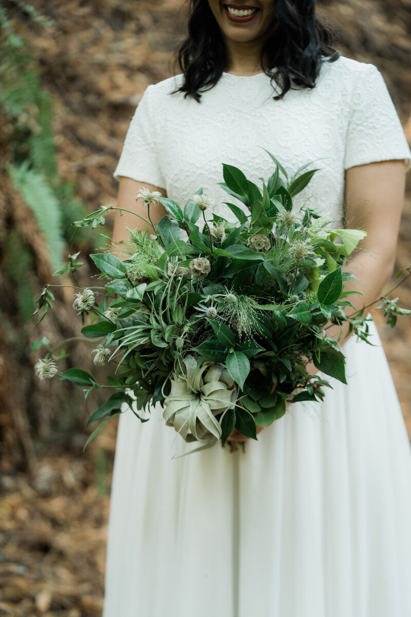 Bride holding greenery bouquet with succulents