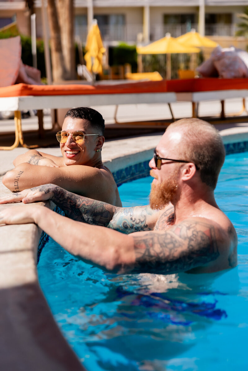 Couple lounging in the pool during golden hour, sharing a relaxed moment with sun-kissed water and resort energy.