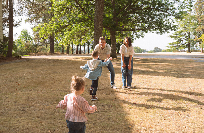 Children running toward their parents during playful outdoor family photos in Irvine, California.