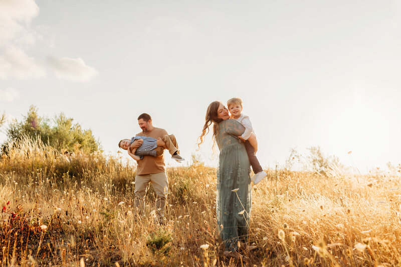 Family is photographed playing together in golden hour light near Vancouver Washington