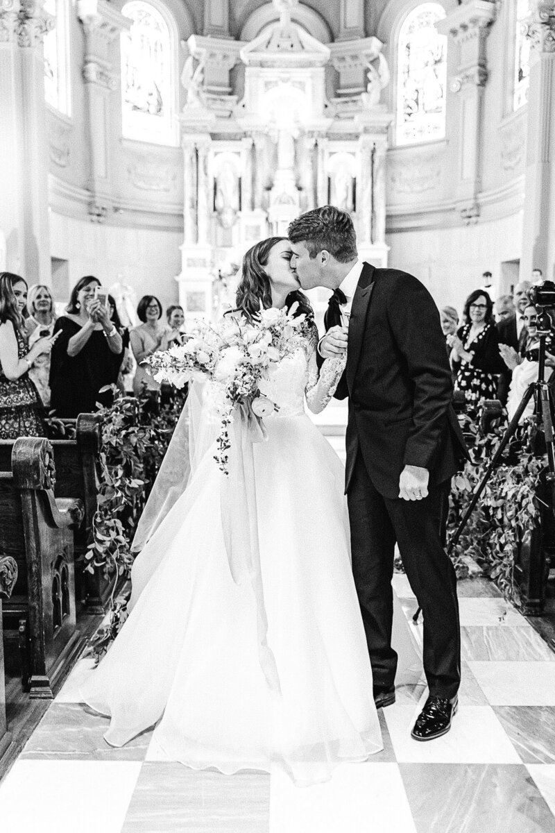 Bride and Groom kissing at the end of the aisle after their wedding ceremony