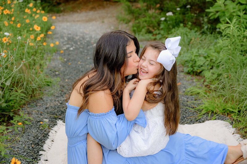 dark hair waxhaw mother kisses the cheek of her daugter