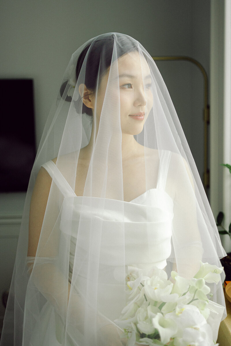 bride portrait when getting ready with flower bouquet and veil