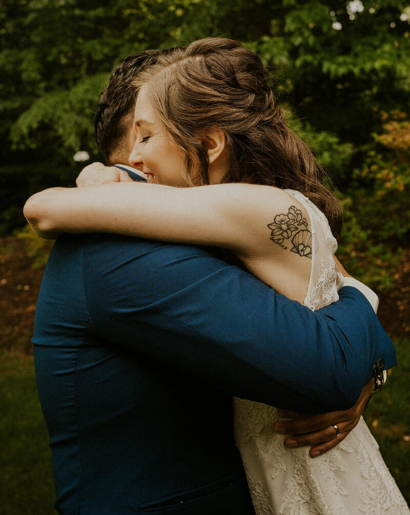 The bride is hugging the groom.