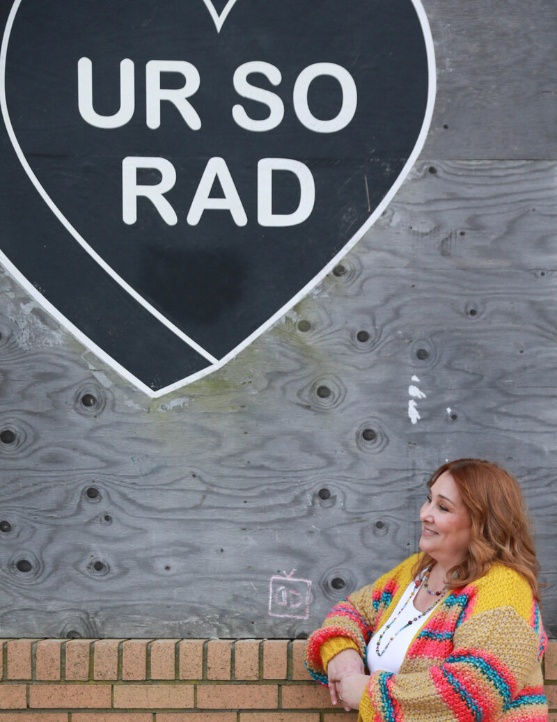 Kim standing in front of a mural 
